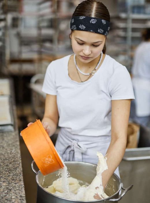 Konditorin von Sailer vermengt Zutaten für Torte per Hand