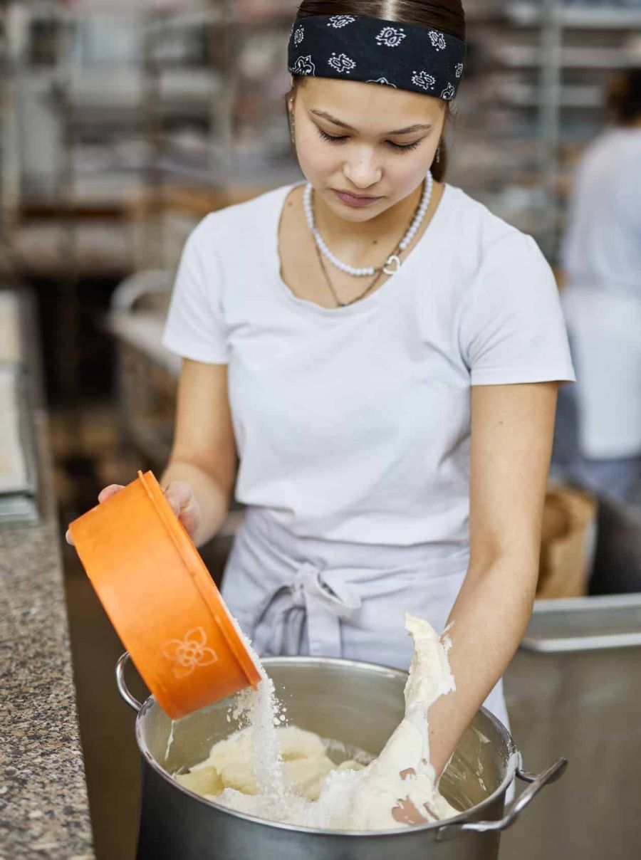 Sailer Konditorin vermengt Tortenzutaten per Hand